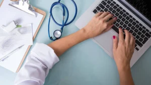 Clinician at a laptop with a stethoscope and clipboard, representing ICD-10 code F31.9 bipolar disorder billing